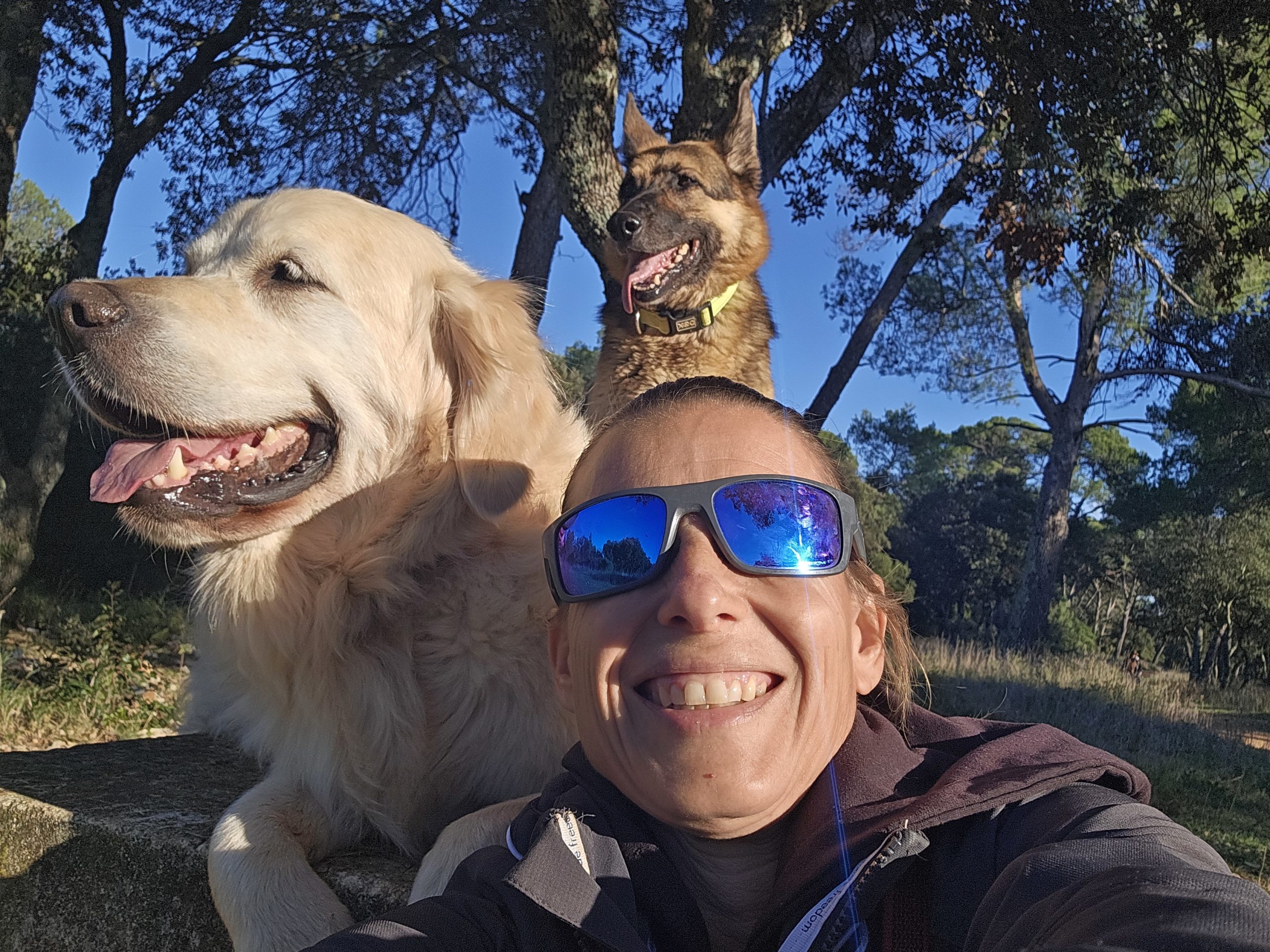 Christelle Iacono de Ami Doggy avec ses deux chiens devant une fontaine