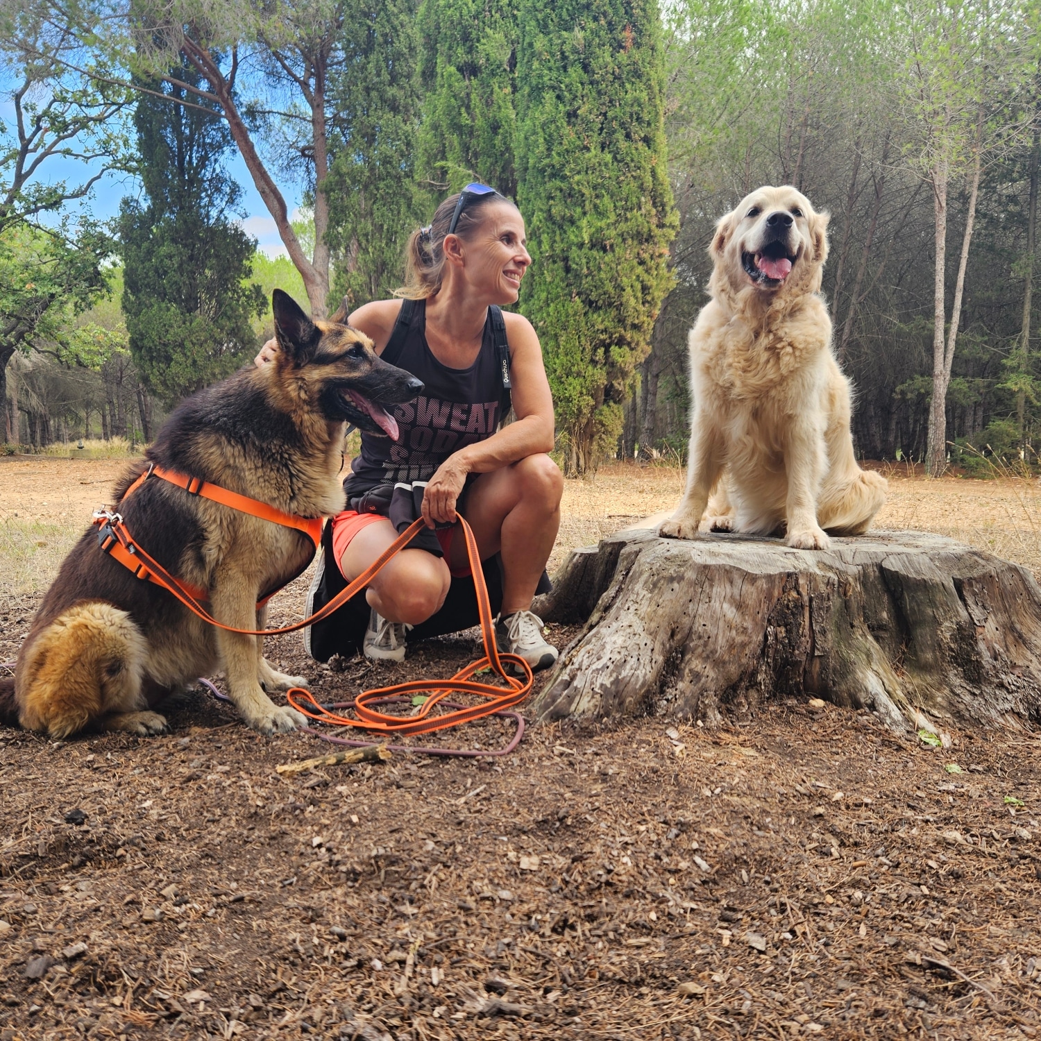 Christelle Iacono de Ami Doggy avec ses deux chiens devant une fontaine